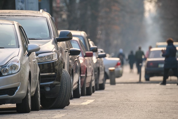 Circulation urbaine avec des voitures garées en ligne côté rue