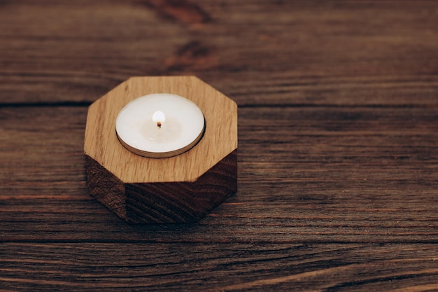 Cire et bougie aromatique dans un chandelier en bois se dresse sur une table en bois