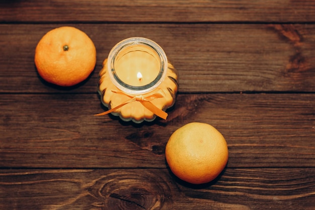 Cire et bougie orange aromatique dans un chandelier se dresse sur une table en bois