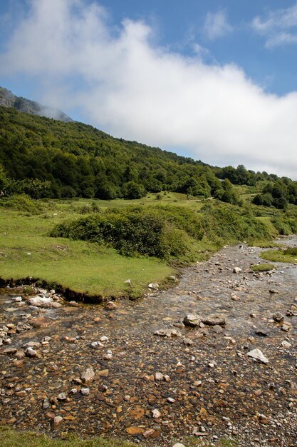 Photo cirque de lescun rivière descend de la montagne française avec le ciel bleu et les nuages