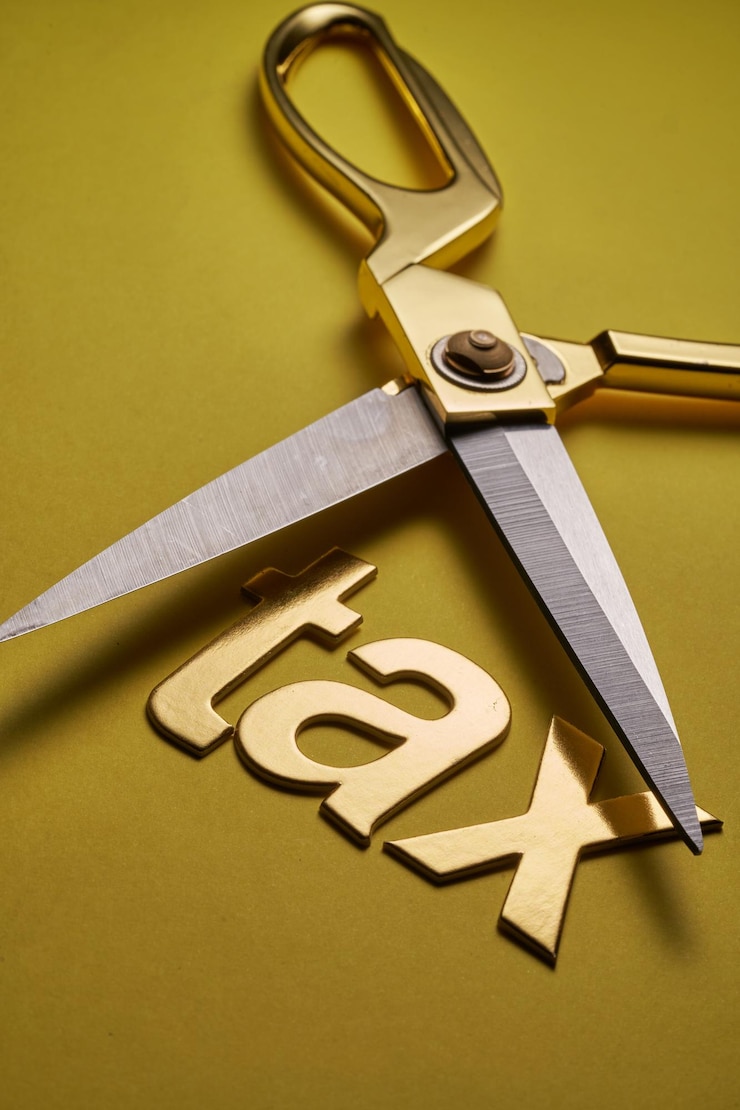 Photo des ciseaux coupant le mot taxe - concept de réduction d'impôt
