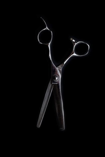 Ciseaux de coupe de cheveux de coiffeur professionnel sur fond noir