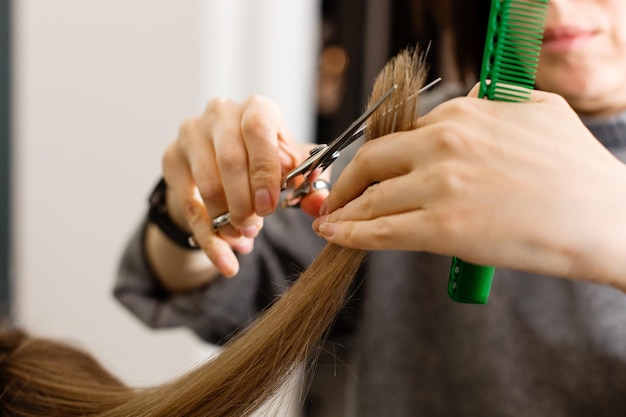 Photo des ciseaux coupent les cheveux des filles