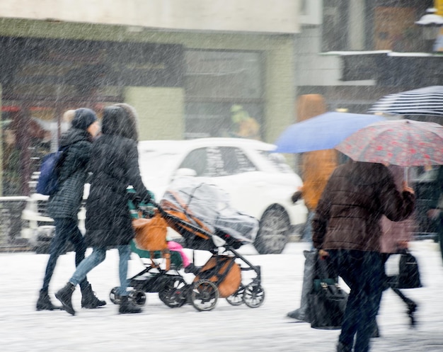 Les citadins occupés se promènent dans la rue en hiver, jour de neige. Flou de mouvement intentionnel. Image défocalisée