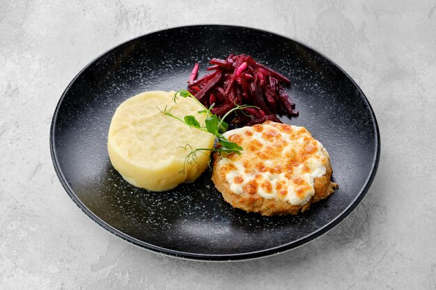 Citlet de Kiev avec purée de pommes de terre et betteraves marinées sur une assiette