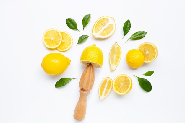 Citron frais et feuilles avec presse-agrumes en bois blanc