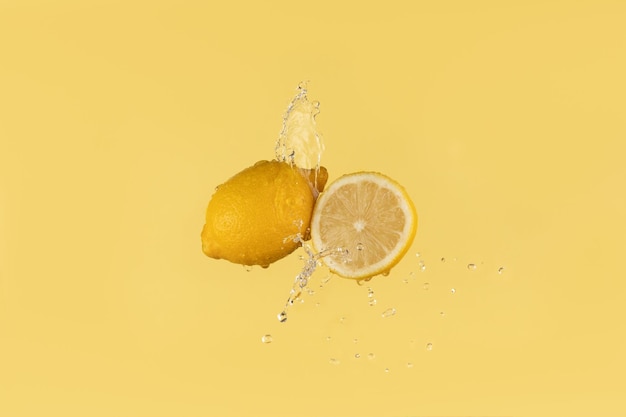 Citron frais sur fond jaune avec des éclaboussures d'eau