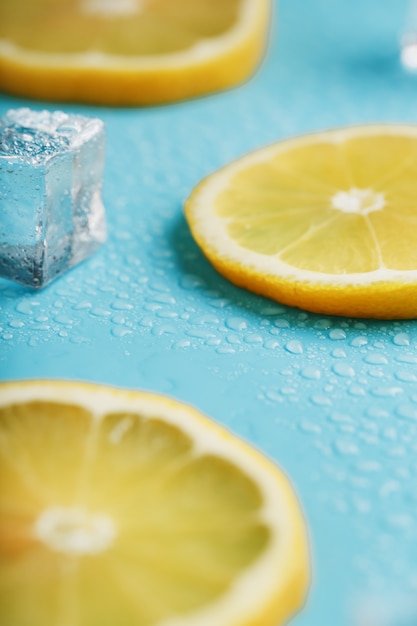 Citron frais avec de la glace et des gouttes sur bleu