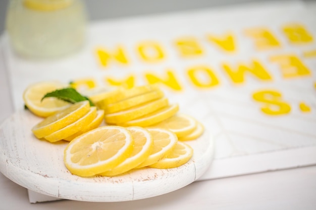 Citron frais tranché sur une planche à découper en bois blanc.