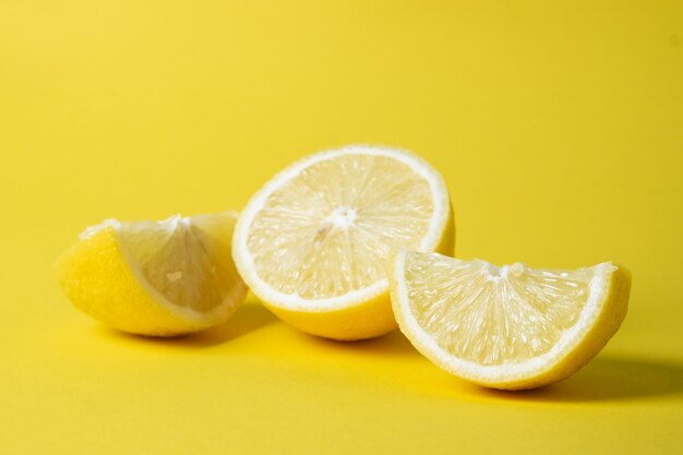 Citron frais tranché sur une surface jaune vif.