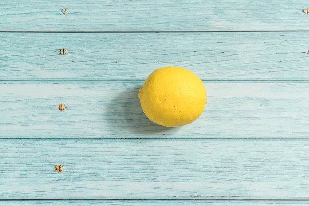 Photo le citron de fruit sur la table bleue à l'arrière-plan frais et clair