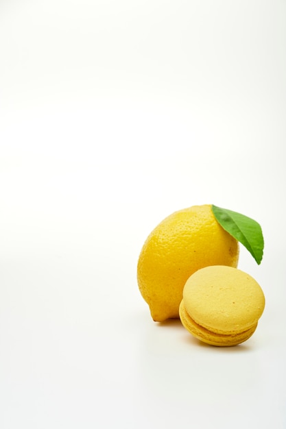 Citron de fruits avec des macarons jaunes sur fond blanc