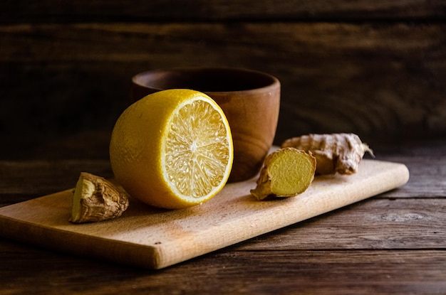 Citron et gingembre sur une planche à découper faisant cuire du thé médicinal.