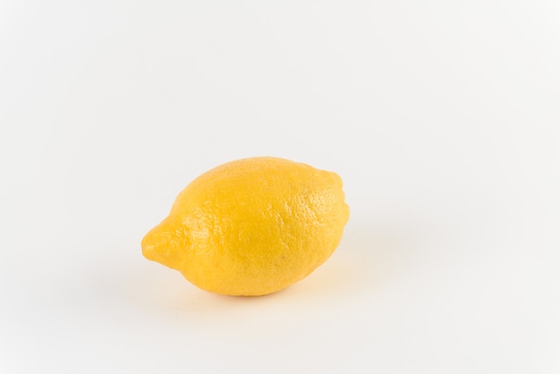 Citron avec des gouttes d'eau sur une surface blanche