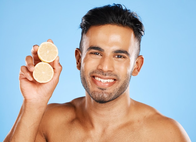 Citron de santé et soins de la peau pour homme avec des agrumes pour la vitamine c faciale et le bien-être avec un sourire sur fond bleu Dermatologie beauté et portrait d'aliments sains pour un éclat propre et une peau saine