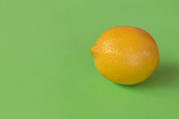 Citron sicilien isolé sur une surface verte