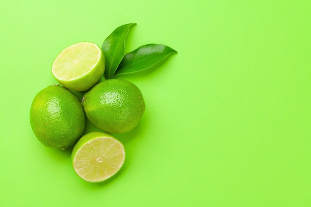 Citron vert d'agrumes mûrs frais sur fond vert