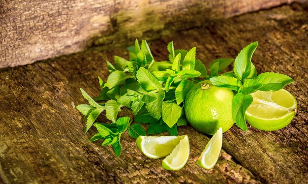 Citron vert à la menthe gros plan sur fond de bois Mojito Agrumes frais