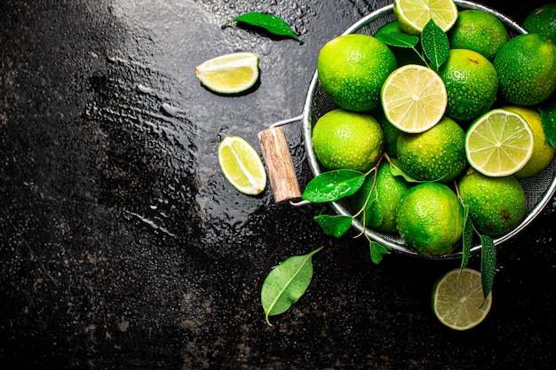 Photo citron vert parfumé avec des feuilles dans une passoire