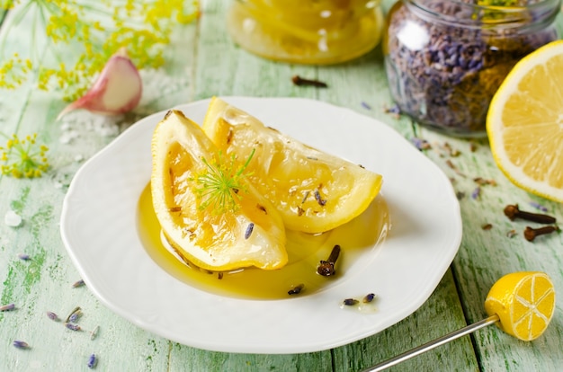 Citrons conservés à l'ail lavande sel et gousses sur une table en bois et épices