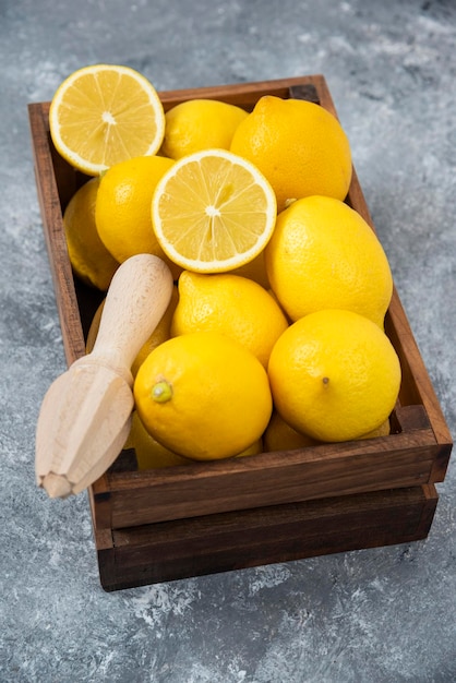 Citrons dans un bol en bois fort sur fond gris