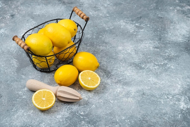 Citrons dans un bol en bois fort sur fond gris