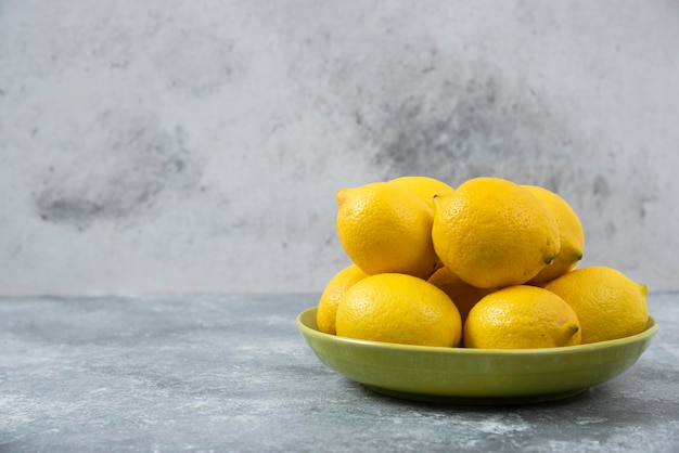 Citrons dans un bol sur fond gris