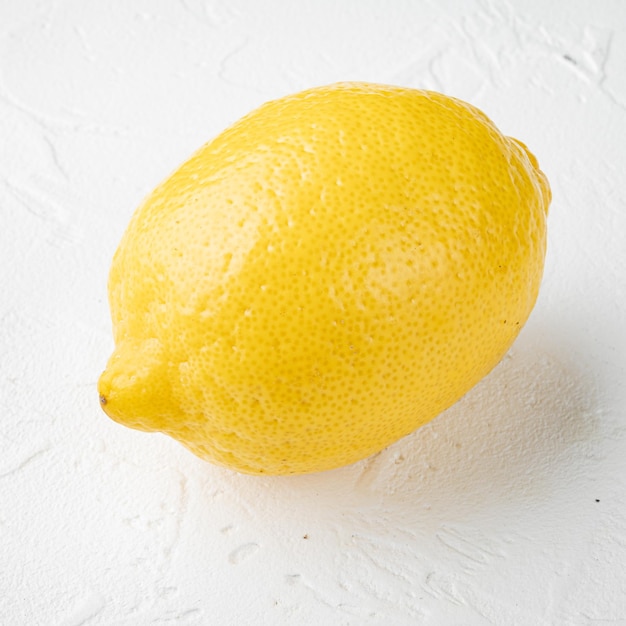 Citrons entiers sur fond de table en pierre blanche