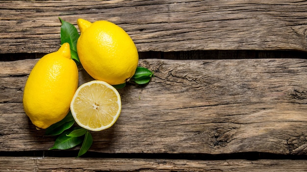 Photo citrons avec des feuilles. sur table en bois.