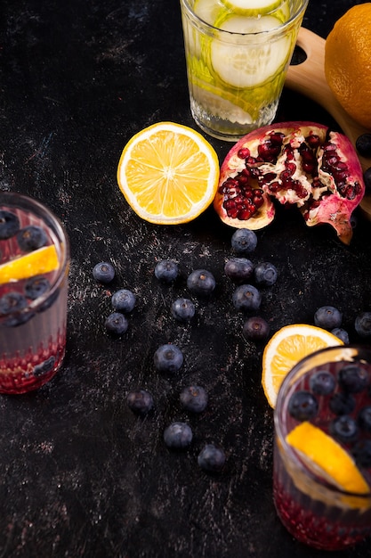 Citrons, grenade et baies sur fond de bois foncé en photo de studio