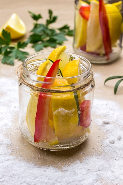 Citrons et piments en conserve salés en pot. Fermentation des aliments. Surface légère