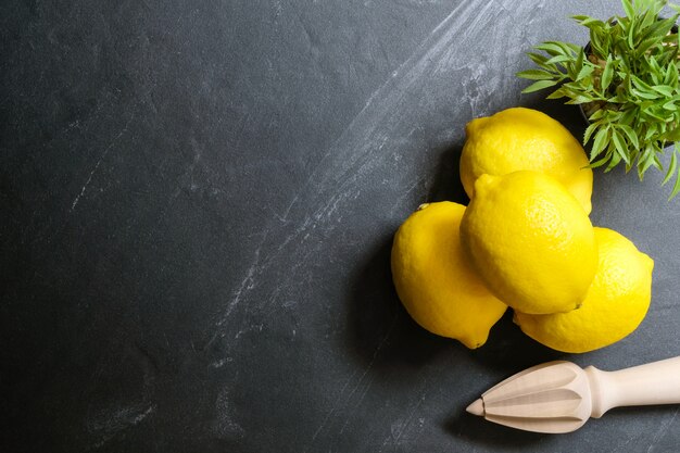 Citrons avec presse-jus sont sur le dessus de la table en pierre. Vue de dessus avec espace de copie, pose à plat. Image clé faible.