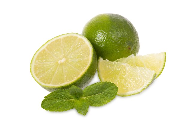 Citrons verts frais et menthe se trouve sur un fond blanc