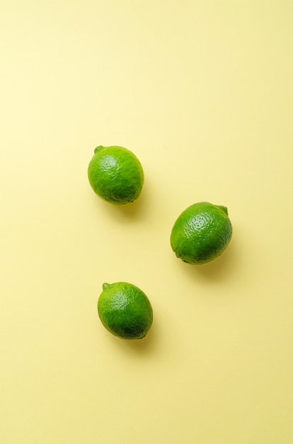 Citrons verts juteux frais sur un uniforme jaune