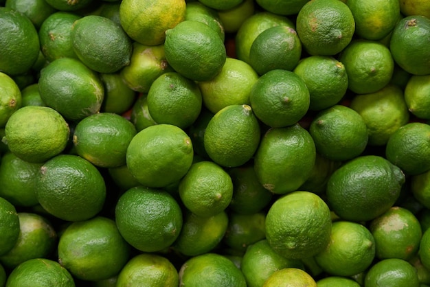 Citrons verts placés sur une étagère à vendre sur un marché