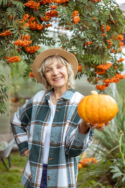 Citrouille Une agricultrice tient une récolte d'automne dans ses mains