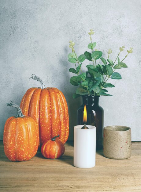 Citrouille artificielle avec bougie allumée sur table en bois Moody Style Halloween concept Copy space