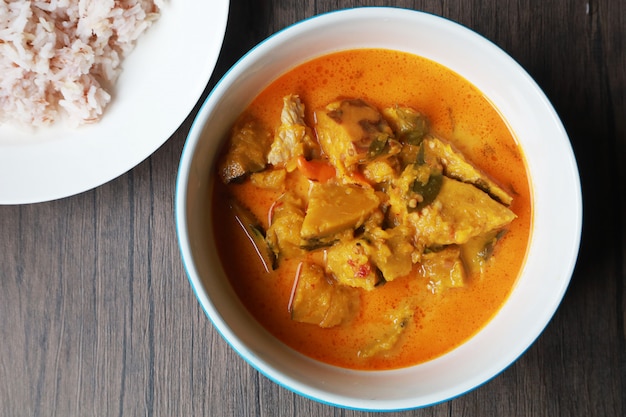 Citrouille au curry dans le bol blanc sur la table en bois