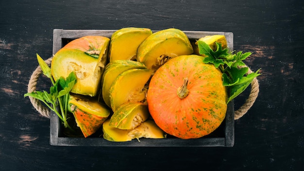 Citrouille dans une boîte en bois Tranches de citrouille Sur une table en bois Espace libre pour le texte Vue de dessus