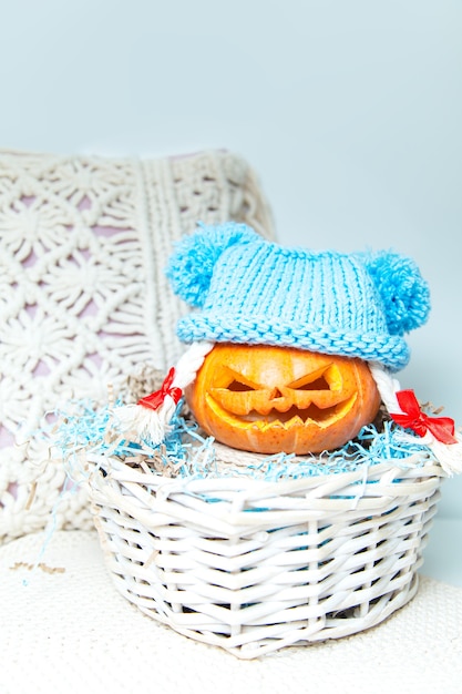 Citrouille drôle avec des tresses dans un chapeau dans un panier. La lanterne de Jack. Halloween insolite, humour.