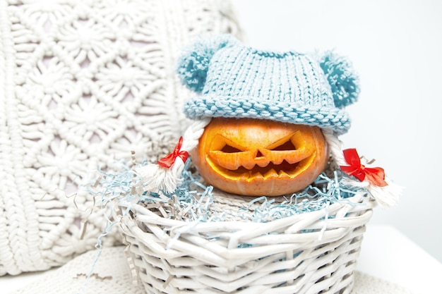 Citrouille drôle avec des tresses dans un chapeau dans un panier. La lanterne de Jack. Halloween insolite, humour.