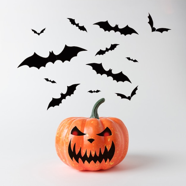 Citrouille d'Halloween avec des chauves-souris sur fond blanc