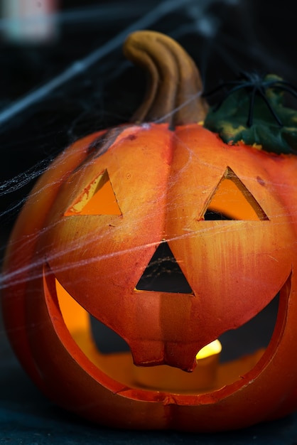 Citrouille d'Halloween avec effrayant sur la fenêtre la nuit