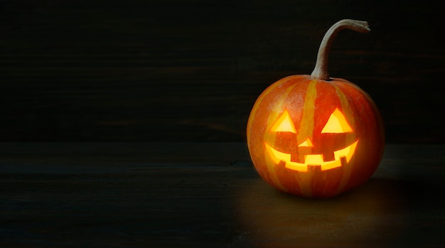 Citrouille d'Halloween sur une table en bois sombre. Fond d'Halloween. Bannière. Espace de copie.