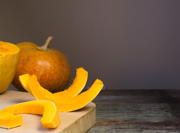 Citrouille mûre et ses tranches sur une planche à découper