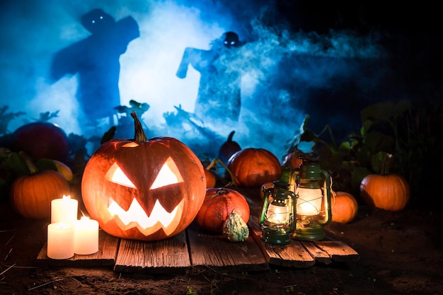 Citrouille orange sur fond sombre avec des épouvantails pour Halloween