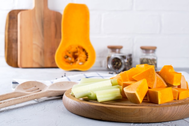 Citrouille en tranches sur une planche de bois. Cuisine maison avec de la citrouille. Nature morte dans la cuisine