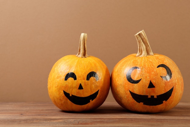 Citrouilles aux visages peints sur fond coloré pour halloween