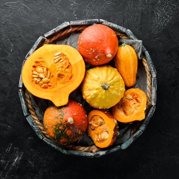 Citrouilles colorées fraîches dans une boîte en bois Légumes d'automne mise à plat Dans l'ancien arrière-plan Vue de dessus Espace libre pour votre texte