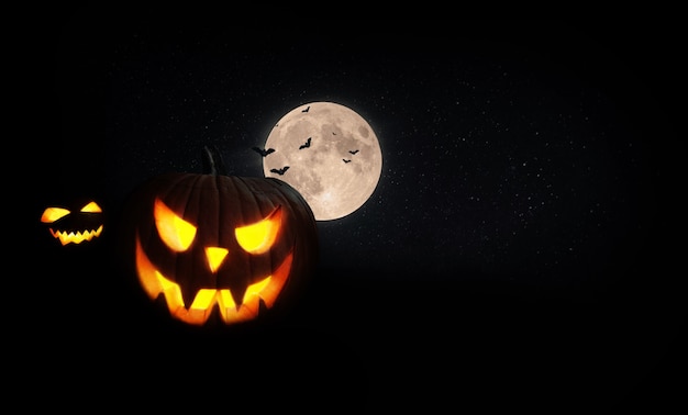 Photo citrouilles effrayantes d'halloween avec la lune et les chauves-souris sur le terrain la nuit. joyeux halloween noir pour la conception